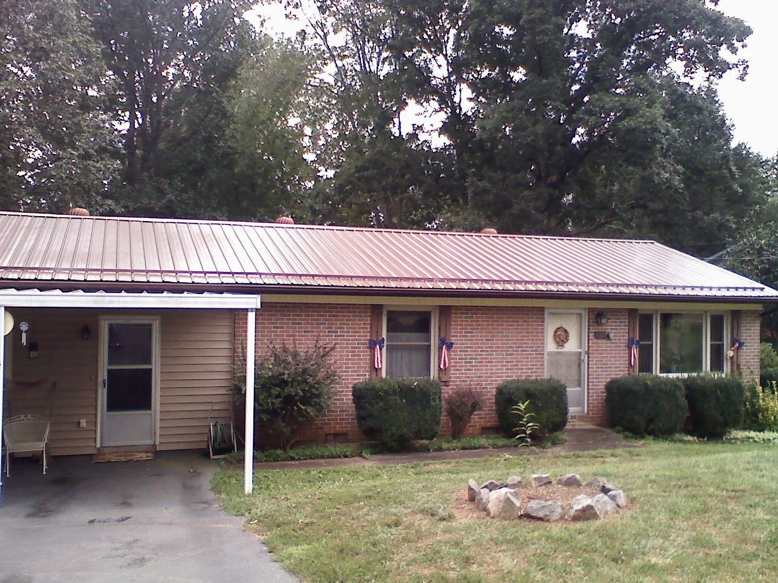 Bronze metal roof and carport on a brick ranch home — Roof Repair work by our crew in Batavia